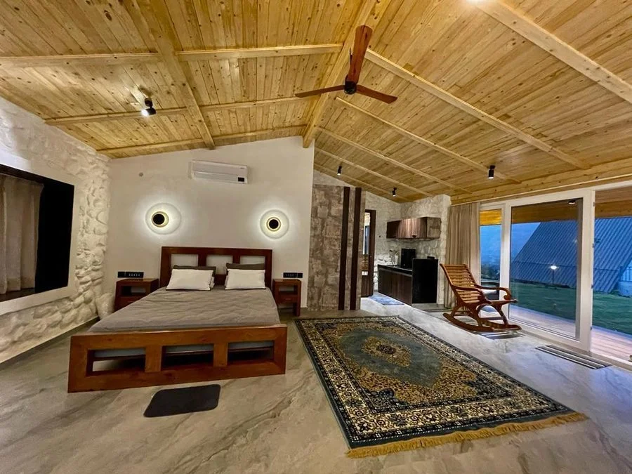 Moonstone Cottage interior with volcanic stone walls and rocking chair, Kamshet